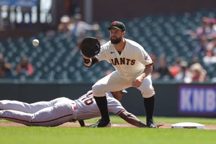 Aug 18, 2022; San Francisco, California, USA; San Francisco Giants first baseman Brandon Belt (9) catches the ball as Arizona Diamondbacks left fielder Stone Garrett (46) dives back to first base during the first inning against the San Francisco Giants at Oracle Park. Mandatory Credit: Sergio Estrada-USA TODAY Sports
