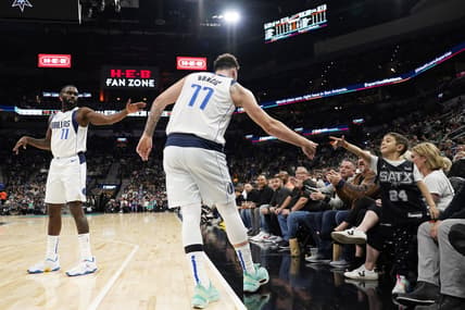 Dec 31, 2022; San Antonio, Texas, USA; Dallas Mavericks guard Luka Doncic (77) reaches for a fan as guard Tim Hardaway Jr. waits during the second half against the San Antonio Spurs at AT&T Center. Mandatory Credit: Scott Wachter-USA TODAY Sports