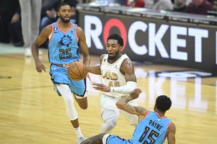 Jan 4, 2023; Cleveland, Ohio, USA; Cleveland Cavaliers guard Donovan Mitchell (45) dribbles between Phoenix Suns forward Mikal Bridges (25) and guard Cameron Payne (15) in the first quarter at Rocket Mortgage FieldHouse. Mandatory Credit: David Richard-USA TODAY Sports