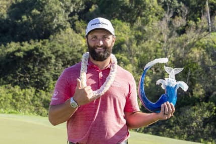 January 8, 2023; Maui, Hawaii, USA; Jon Rahm hoists the trophy on the 18th hole during the final round of the Sentry Tournament of Champions golf tournament at Kapalua Resort - The Plantation Course. Mandatory Credit: Kyle Terada-USA TODAY Sports