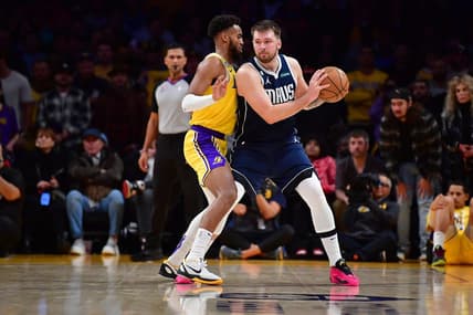 Jan 12, 2023; Los Angeles, California, USA; Dallas Mavericks guard Luka Doncic (77) moves the ball against Los Angeles Lakers forward Troy Brown Jr. (7) during overtime at Crypto.com Arena. Mandatory Credit: Gary A. Vasquez-USA TODAY Sports