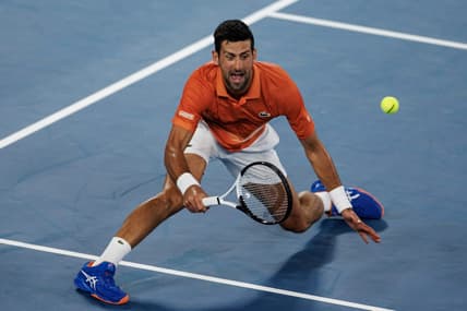 Jan 13, 2023; Melbourne, Victoria, Australia; Novak Djokovic of Serbia hits a shot during an exhibition practice match against Nick Kyrgios of Australia on Rod Laver Arena at Melbourne Park. Mandatory Credit: Mike Frey-USA TODAY Sports