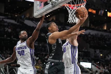 Jan 15, 2023; San Antonio, Texas, USA;  San Antonio Spurs forward Keldon Johnson (3) shoots in front of Sacramento Kings forwards Harrison Barnes (40) and Domantas Sabonis (10) in the first half at the AT&T Center. Mandatory Credit: Daniel Dunn-USA TODAY Sports