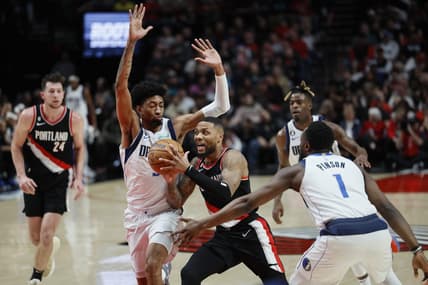 Jan 15, 2023; Portland, Oregon, USA; Portland Trail Blazers point guard Damian Lillard (0) drives for the basket between Dallas Mavericks forward Christian Wood (35, left) and  guard Theo Pinson (1) during the first half at Moda Center. Mandatory Credit: Soobum Im-USA TODAY Sports