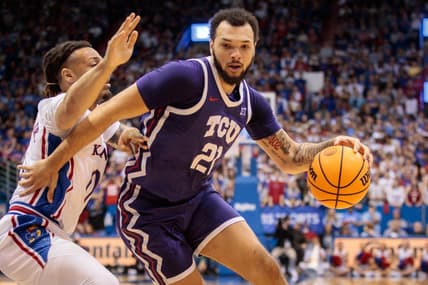Jan 21, 2023; Lawrence, Kansas, USA; TCU Horned Frogs forward JaKobe Coles (21) drives around Kansas Jayhawks guard Bobby Pettiford Jr. (0) during the first half at Allen Fieldhouse. Mandatory Credit: William Purnell-USA TODAY Sports