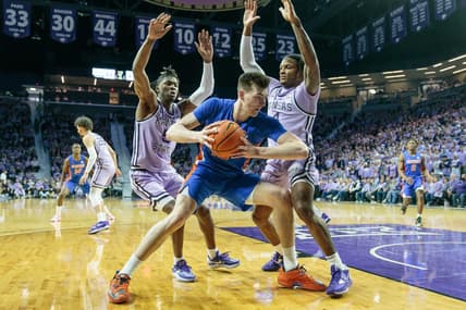 Jan 28, 2023; Manhattan, Kansas, USA; Florida Gators forward Colin Castleton (12) tries to drive the baseline around Kansas State Wildcats guard Cam Carter (5) and Kansas State Wildcats guard Tykei Greene (4) during the second half at Bramlage Coliseum. Mandatory Credit: William Purnell-USA TODAY Sports