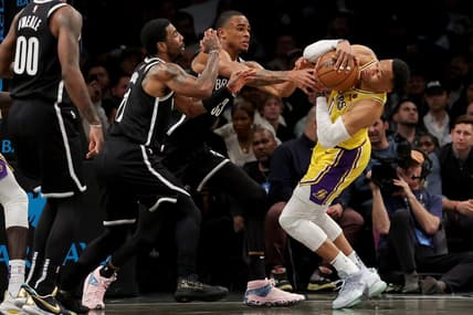 Jan 30, 2023; Brooklyn, New York, USA; Los Angeles Lakers guard Russell Westbrook (0) fights for the ball against Brooklyn Nets guard Kyrie Irving (11) and center Nic Claxton (33) during the first quarter at Barclays Center. Mandatory Credit: Brad Penner-USA TODAY Sports