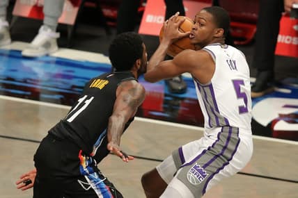 Feb 23, 2021; Brooklyn, New York, USA; Sacramento Kings point guard De'Aaron Fox (5) controls the ball against Brooklyn Nets point guard Kyrie Irving (11) during the third quarter at Barclays Center. Mandatory Credit: Brad Penner-USA TODAY Sports