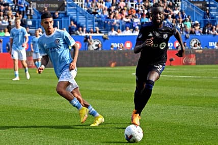 Oct 23, 2022; Montreal, Quebec, Canada; CF Montreal forward Kei Kamara (23) and New York City midfielder Santiago Rodriguez (20) go for the ball during the first half during the conference semifinals for the Audi 2022 MLS Cup Playoffs at Stade Saputo. Mandatory Credit: David Kirouac-USA TODAY Sports