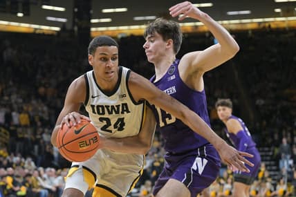 Jan 31, 2023; Iowa City, Iowa, USA; Iowa Hawkeyes forward Kris Murray (24) goes to the basket as Northwestern Wildcats guard Brooks Barnhizer (13) defends during the second half at Carver-Hawkeye Arena. Mandatory Credit: Jeffrey Becker-USA TODAY Sports