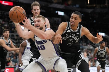 Feb 1, 2023; San Antonio, Texas, USA;  Sacramento Kings forward Domantas Sabonis (10) reaches for a ball in front of San Antonio Spurs forward Keldon Johnson (3) in the second half at the AT&T Center. Mandatory Credit: Daniel Dunn-USA TODAY Sports