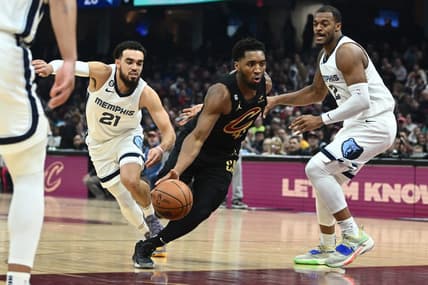 Feb 2, 2023; Cleveland, Ohio, USA; Cleveland Cavaliers guard Donovan Mitchell (45) drives to the basket between Memphis Grizzlies guard Tyus Jones (21) and forward Xavier Tillman (2) during the first half at Rocket Mortgage FieldHouse. Mandatory Credit: Ken Blaze-USA TODAY Sports