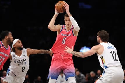 Feb 4, 2023; Brooklyn, New York, USA; Washington Wizards center Kristaps Porzingis (6) controls the ball against Brooklyn Nets guard Patty Mills (8) and forward Joe Harris (12) during the third quarter at Barclays Center. Mandatory Credit: Brad Penner-USA TODAY Sports