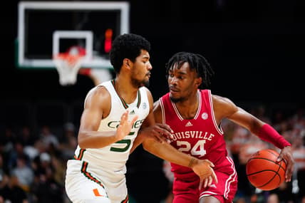 Feb 11, 2023; Coral Gables, Florida, USA; Louisville Cardinals forward Jae'Lyn Withers (24) dibbles the ball past Miami (Fl) Hurricanes guard Harlond Beverly (5) during the first half at Watsco Center. Mandatory Credit: Rich Storry-USA TODAY Sports
