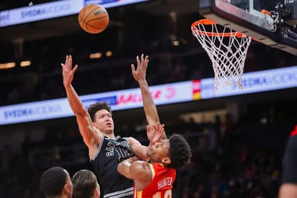 Feb 11, 2023; Atlanta, Georgia, USA; San Antonio Spurs forward Isaiah Roby (18) shoots over Atlanta Hawks forward De'Andre Hunter (12) in the second quarter at State Farm Arena. Mandatory Credit: Brett Davis-USA TODAY Sports