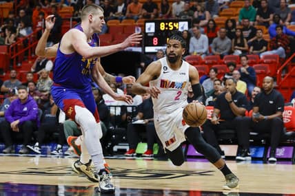 Feb 13, 2023; Miami, Florida, USA; Miami Heat guard Gabe Vincent (2) drives to the basket as Denver Nuggets center Nikola Jokic (15) defends during the first quarter at Miami-Dade Arena. Mandatory Credit: Sam Navarro-USA TODAY Sports