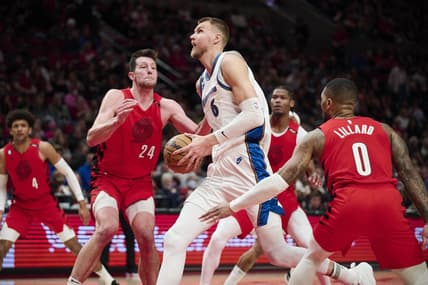 Feb 14, 2023; Portland, Oregon, USA; Washington Wizards center Kristaps Porzingis (6) drives to the basket during the first half against Portland Trail Blazers forward Drew Eubanks (24) and guard Damian Lillard (0) at Moda Center. Mandatory Credit: Troy Wayrynen-USA TODAY Sports