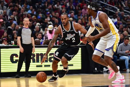 Feb 14, 2023; Los Angeles, California, USA; Los Angeles Clippers forward Kawhi Leonard (2) moves to the basket against Golden State Warriors forward Kevon Looney (5) during the first half at Crypto.com Arena. Mandatory Credit: Gary A. Vasquez-USA TODAY Sports