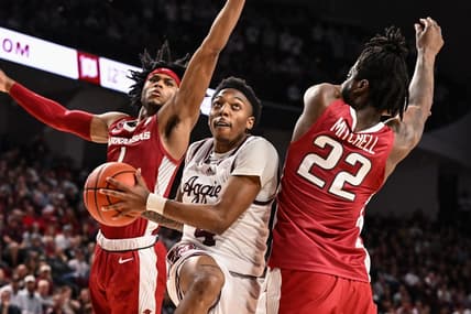 Feb 15, 2023; College Station, Texas, USA; Texas A&M Aggies guard Wade Taylor IV (4) drives through Arkansas Razorbacks guard Ricky Council IV (1) and forward Makhel Mitchell (22) during the second half at Reed Arena. Mandatory Credit: Maria Lysaker-USA TODAY Sports