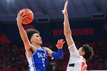Feb 18, 2023; Syracuse, New York, USA; Duke Blue Devils guard Tyrese Proctor (5) shoots the ball against Syracuse Orange center Jesse Edwards (14) during the second half at the JMA Wireless Dome. Mandatory Credit: Rich Barnes-USA TODAY Sports