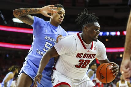 Feb 19, 2023; Raleigh, North Carolina, USA;  North Carolina State Wolfpack forward D.J. Burns Jr. (30) maintains possession against North Carolina Tar Heels forward Armando Bacot (5) during the first half of the game at PNC Arena. Mandatory Credit: Jaylynn Nash-USA TODAY Sports