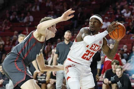 Feb 21, 2023; Norman, Oklahoma, USA; Texas Tech Red Raiders guard De'Vion Harmon (23) works to pass around Oklahoma Sooners forward Jacob Groves (34) during the first half at Lloyd Noble Center. Mandatory Credit: Alonzo Adams-USA TODAY Sports