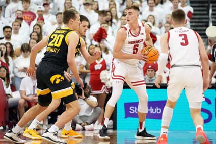 Feb 22, 2023; Madison, Wisconsin, USA; Wisconsin Badgers forward Tyler Wahl (5) looks to pass under coverage by Iowa Hawkeyes forward Payton Sandfort (20) and forward Filip Rebraca (0) during the first half at the Kohl Center. Mandatory Credit: Kayla Wolf-USA TODAY Sports