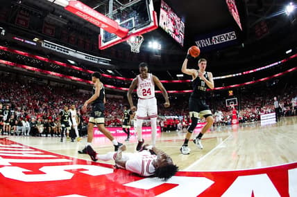 Feb 22, 2023; Raleigh, North Carolina, USA; North Carolina State Wolfpack guard Jarkel Joiner (1) scores and celebrates on the floor with forward Ernest Ross (24) as Wake Forest Demon Deacons forward Andrew Carr (11) looks on during the first half against Wake Forest Demon Deacons at PNC Arena. Mandatory Credit: Jaylynn Nash-USA TODAY Sports