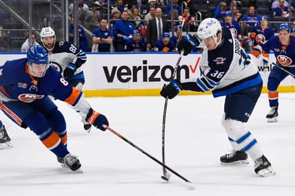 Feb 22, 2023; Elmont, New York, USA; Winnipeg Jets center Morgan Barron (36) attempts a shot defended by New York Islanders defenseman Noah Dobson (8) during the third period at UBS Arena. Mandatory Credit: Dennis Schneidler-USA TODAY Sports