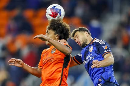Feb 25, 2023; Cincinnati, Ohio, USA; Houston Dynamo FC midfielder Adalberto Carrasquilla (20) heads the ball against FC Cincinnati defender Matt Miazga (21) in the second half at TQL Stadium. Mandatory Credit: Katie Stratman-USA TODAY Sports
