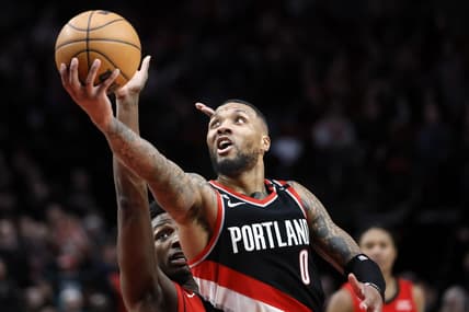 Feb 26, 2023; Portland, Oregon, USA; Portland Trail Blazers point guard Damian Lillard (0) shoots the ball past Houston Rockets small forward Jae'Sean Tate (8, left) during the second half at Moda Center. Mandatory Credit: Soobum Im-USA TODAY Sports