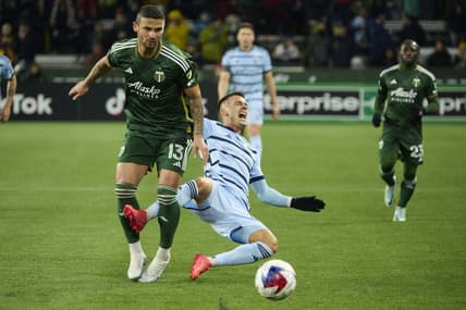 Feb 27, 2023; Portland, Oregon, USA; Sporting Kansas City midfielder Erik Thommy (26) runs into Portland Timbers defender Dario Zuparic (13) during the first half at Providence Park. Mandatory Credit: Troy Wayrynen-USA TODAY Sports