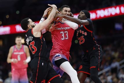 Mar 2, 2023; Washington, District of Columbia, USA; Washington Wizards forward Kyle Kuzma (33) drives to the basket as Toronto Raptors guard Fred VanVleet (23) and Raptors forward Chris Boucher (25) defend in the fourth quarter at Capital One Arena. Mandatory Credit: Geoff Burke-USA TODAY Sports