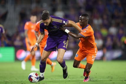 Mar 4, 2023; Orlando, Florida, USA; Orlando City forward Ercan Kara (9) is tackled by FC Cincinnati midfielder Obinna Nwobodo (5) at Exploria Stadium. Mandatory Credit: Nathan Ray Seebeck-USA TODAY Sports