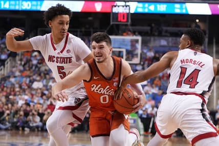 Mar 8, 2023; Greensboro, NC, USA; Virginia Tech Hokies guard Hunter Cattoor (0) with the ball as North Carolina State Wolfpack guard Jack Clark (5) and guard Casey Morsell (14) defend in the first half of the second round at Greensboro Coliseum. Mandatory Credit: Bob Donnan-USA TODAY Sports