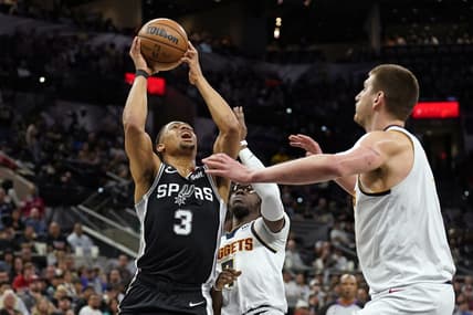 Mar 10, 2023; San Antonio, Texas, USA; San Antonio Spurs forward Keldon Johnson (3) drives to the basket against Denver Nuggets guard Reggie Jackson (7) and center Nikola Jokic (15) during the first half at AT&T Center. Mandatory Credit: Scott Wachter-USA TODAY Sports