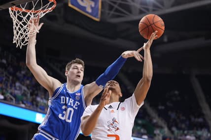 Mar 10, 2023; Greensboro, NC, USA;  Miami (Fl) Hurricanes guard Isaiah Wong (2) shoots as Duke Blue Devils center Kyle Filipowski (30) defends in the second half during the semifinals of the ACC Tournament at Greensboro Coliseum. Mandatory Credit: Bob Donnan-USA TODAY Sports