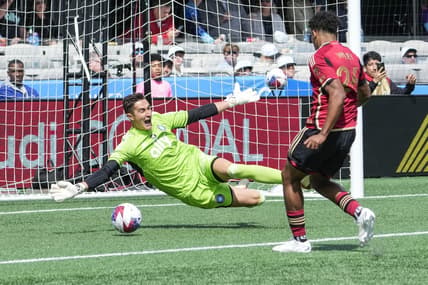 Mar 11, 2023; Charlotte, North Carolina, USA;  Atlanta United defender Caleb Wiley (26) shoots for a scoring goal against Charlotte FC goalkeeper Pablo Sisniega (23) during the first half at Bank of America Stadium. Mandatory Credit: Jim Dedmon-USA TODAY Sports