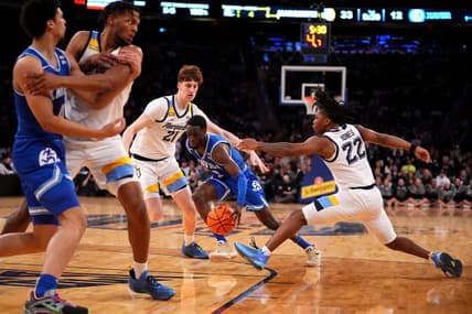 Mar 11, 2023; New York, NY, USA; Xavier Musketeers guard Souley Boum (0) drives as Marquette Golden Eagles forward Ben Gold (21) and Marquette Golden Eagles guard Sean Jones (22) defend in the first half at Madison Square Garden. Mandatory Credit: Kareem Elgazzar-USA TODAY Sports