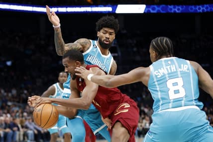 Mar 12, 2023; Charlotte, North Carolina, USA; Cleveland Cavaliers forward Evan Mobley (4) drives through Charlotte Hornets guard Dennis Smith Jr. (8) and center Nick Richards (4) during the first half at Spectrum Center. Mandatory Credit: Brian Westerholt-USA TODAY Sports