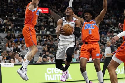 Mar 12, 2023; San Antonio, Texas, USA; San Antonio Spurs guard Devonte' Graham (4) drives to the basket between Oklahoma City Thunder guard Josh Giddey (3) and forward Jalen Williams (8) during the first half at AT&T Center. Mandatory Credit: Scott Wachter-USA TODAY Sports