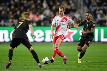 Mar 12, 2023; Los Angeles, California, USA; New England Revolution defender Henry Kessler (4) dribbles the ball against Los Angeles FC forward Stipe Biuk (7) and forward Denis Bouanga (99) during the first half at BMO Stadium. Mandatory Credit: Orlando Ramirez-USA TODAY Sports