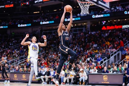 Mar 17, 2023; Atlanta, Georgia, USA; Atlanta Hawks forward De'Andre Hunter (12) dunks past Golden State Warriors guard Jordan Poole (3) in the second quarter at State Farm Arena. Mandatory Credit: Brett Davis-USA TODAY Sports