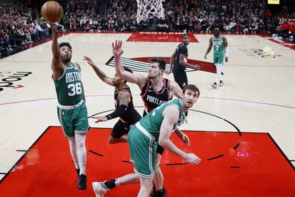 Mar 17, 2023; Portland, Oregon, USA; Boston Celtics point guard Marcus Smart (36) shoots the ball against Portland Trail Blazers shooting guard Anfernee Simons (1, center) and power forward Drew Eubanks (24) uring the first half at Moda Center. Mandatory Credit: Soobum Im-USA TODAY Sports