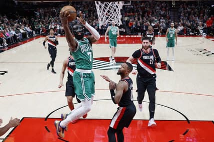 Mar 17, 2023; Portland, Oregon, USA; dBoston Celtics shooting guard Jaylen Brown (7) shoots the ball against Portland Trail Blazers point guard Damian Lillard (0) uring the first half at Moda Center. Mandatory Credit: Soobum Im-USA TODAY Sports