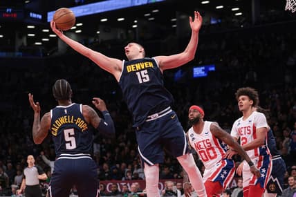 Mar 19, 2023; Brooklyn, New York, USA; Denver Nuggets center Nikola Jokic (15) rebounds in front of guard Kentavious Caldwell-Pope (5) and Brooklyn Nets forward Royce O'Neale (00) and forward Cameron Johnson (2)  during the second half at Barclays Center. Mandatory Credit: Vincent Carchietta-USA TODAY Sports