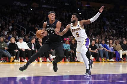 Mar 19, 2023; Los Angeles, California, USA; Orlando Magic forward Paolo Banchero (left) dribbles the ball against Los Angeles Lakers guard Malik Beasley in the first half at Crypto.com Arena. Mandatory Credit: Kirby Lee-USA TODAY Sports