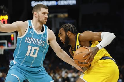 Mar 20, 2023; Charlotte, North Carolina, USA; Indiana Pacers forward Oshae Brissett (12) drives against Charlotte Hornets guard Svi Mykhailiuk (10) during the first half at Spectrum Center. Mandatory Credit: Nell Redmond-USA TODAY Sports