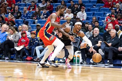 Mar 21, 2023; New Orleans, Louisiana, USA;  San Antonio Spurs guard Devonte' Graham (4) dribbles against New Orleans Pelicans forward Naji Marshall (8) during the first half at Smoothie King Center. Mandatory Credit: Stephen Lew-USA TODAY Sports