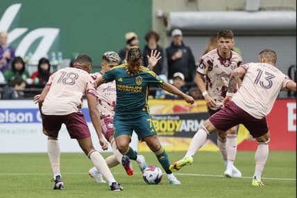 Mar 25, 2023; Portland, Oregon, USA; LA Galaxy midfielder Efrain Alvarez (7) controls the ball against Portland Timbers defender Zac McGraw (18) and Dario Zuparic (13) during the second half at Providence Park. Mandatory Credit: Soobum Im-USA TODAY Sports